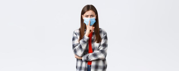격리 사회적 거리와 감정 개념에 대한 코로나바이러스 발병 여가 짜증나는 얼굴로 찡그린 의료 마스크를 쓴 진지한 소녀는 조용히 말하거나 침묵을 유지합니다