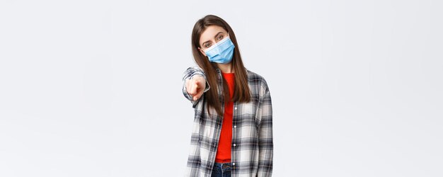 Coronavirus outbreak leisure on quarantine social distancing and emotions concept Young determined girl making choice pointing finger at camera need you wear medical mask ask join team