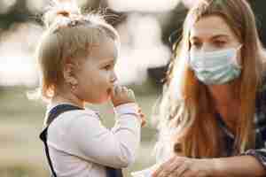 Foto gratuita tema coronavirus. famiglia in un parco estivo. donna in una camicia di cella.