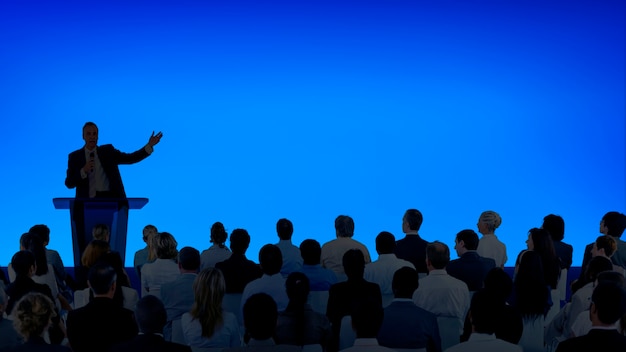 Corporate businessman giving a presentation to a large audience
