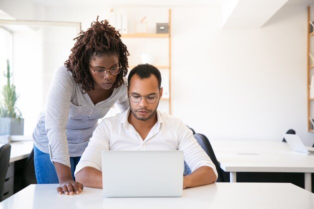 Corporate trainer watching intern making report