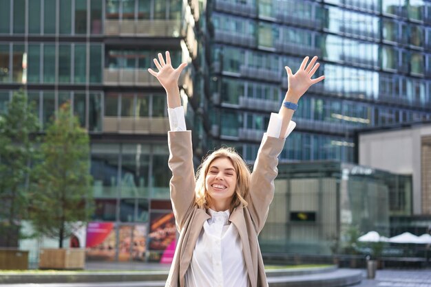 거리의 행복한 여성 사업가가 손을 위로 들고 t를 들고 밖에서 그녀의 승리를 축하하는 기업 여성