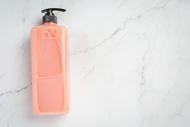 Cosmetic bottle strawberry shampoo on white surface