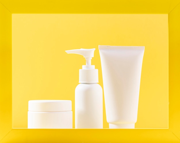 Foto gratuita contenitori cosmetici con sfondo giallo