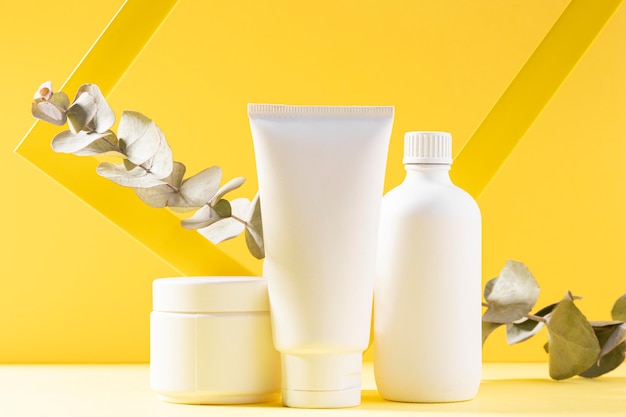 Free photo cosmetic containers on yellow background