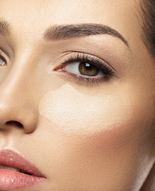 Тональная основа косметического макияжа нанесена на лицо женщины. Концепция ухода за кожей.