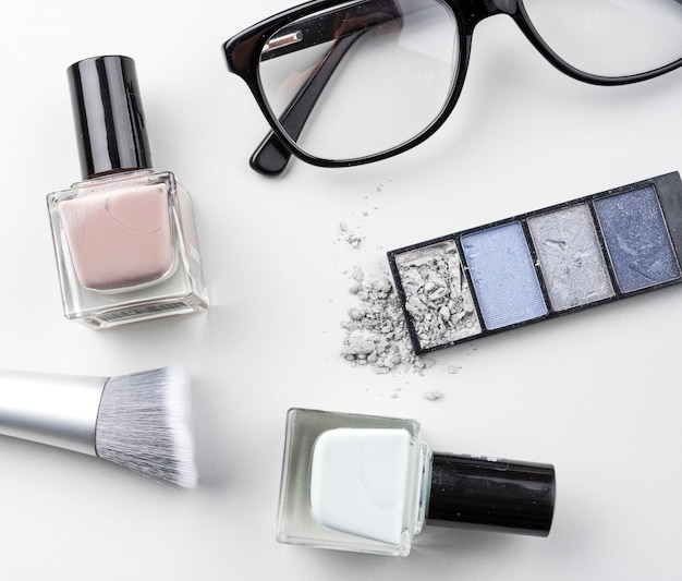 Cosmetic products with glasses flat lay
