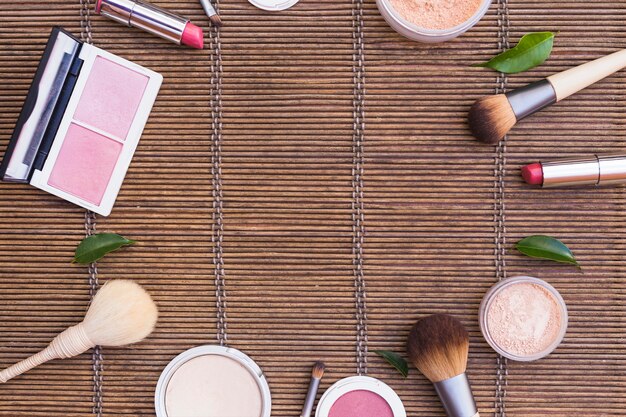 Cosmetics products arranged in circular shape on placemat