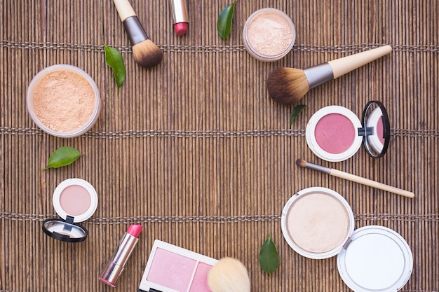 Cosmetics products arranged in circular shape on wooden background