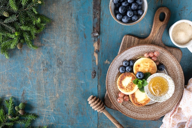 カッテージ チーズのパンケーキ ハニースグリとブルーベリーを青の背景にチーズケーキ 新年の朝食に甘い食べ物
