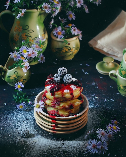 Сырники, сырники, творожные оладьи с замороженными ягодами (ежевика) и сахарной пудрой в винтажной тарелке. Изысканный завтрак