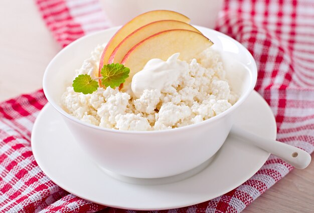 Cottage cheese with apples and sour cream for breakfast close up
