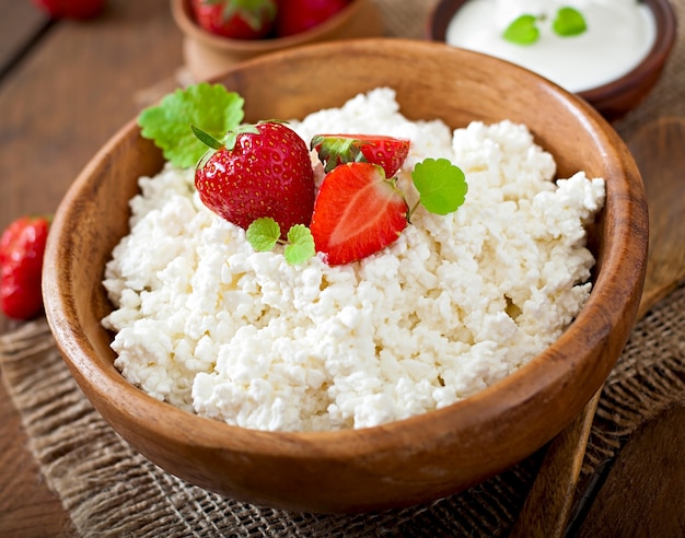 Cottage cheese with strawberries in a wooden bowl