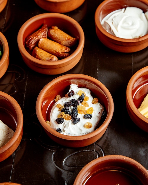 Cottage cheese with sultanas and sausages in earthenware