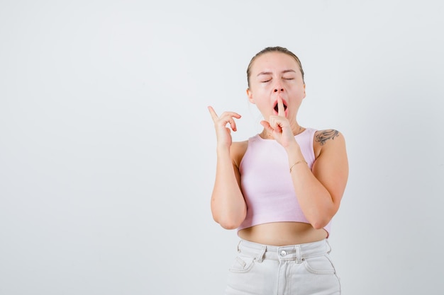 Couching girl is putting her finger on her mouth  on white background