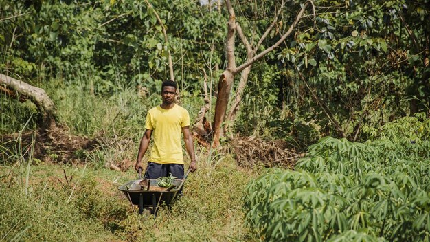 Countryside man pushing a wheelbarrow