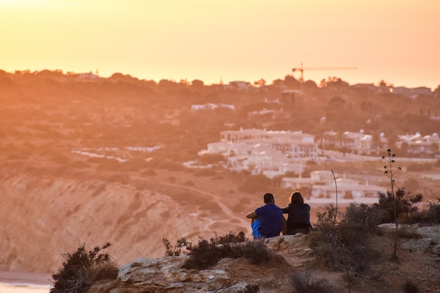 Couple admiring the sunset over the beach