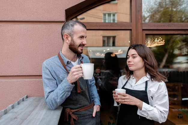 Couple in aprons enjoying coffee outside