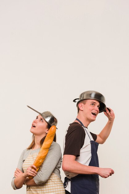 調理器具を頭の上に立っているエプロンのカップル