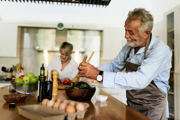 Foto gratuita le coppie stanno cucinando insieme in cucina