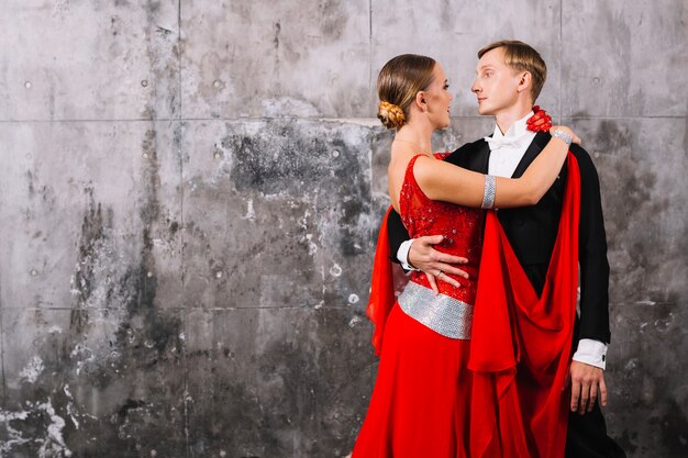 Couple in ballroom costumes embracing during dance