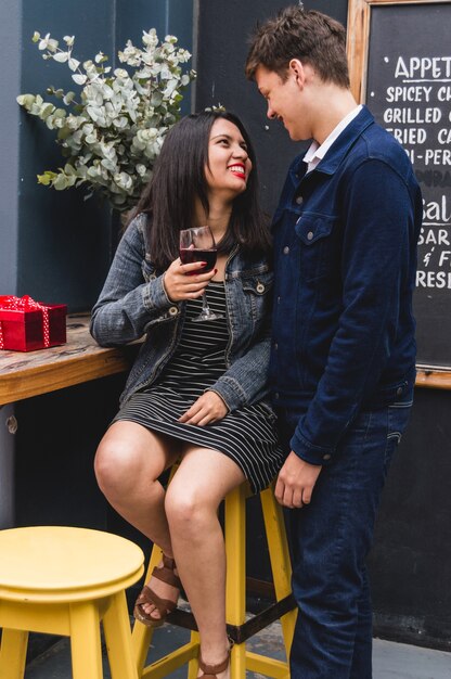 Couple in a bar and she with a glass of wine in hand