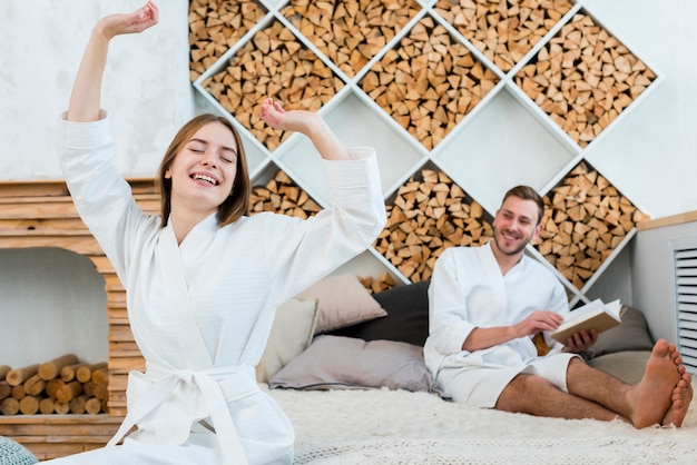 Free photo couple in bathrobes waking up in bed