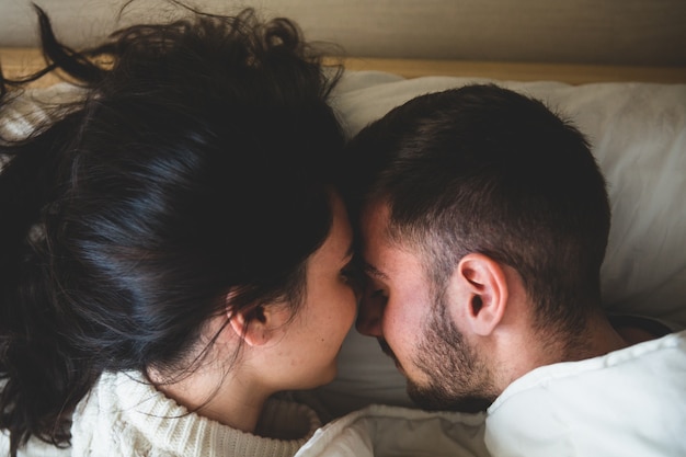 Couple in bed head with head