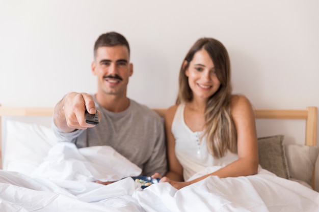 Couple in bed with remote control