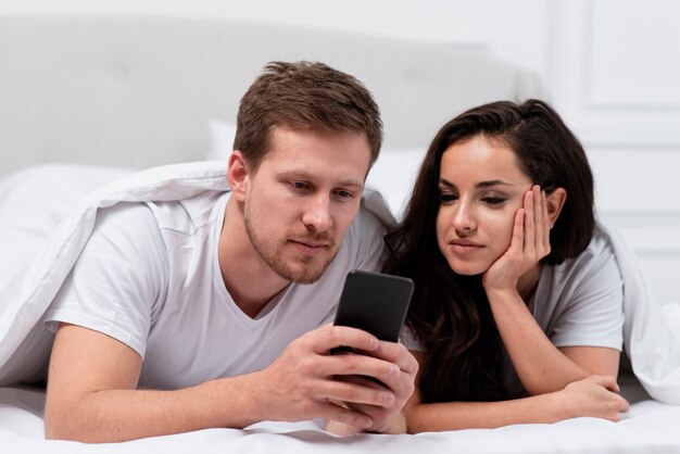 침대에서 소셜 미디어에 중독되는 커플