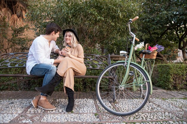 Couple on the bench with bicycle and flowers