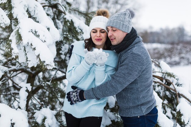 Couple blowing at snow