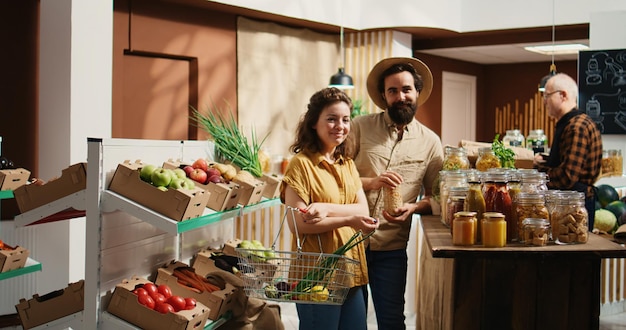 Foto gratuita la coppia compra alimenti per la dispensa dal negozio biologico.