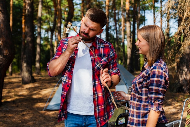 Couple camping eating marshmellow