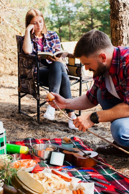 Couple camping and preparing food for meal