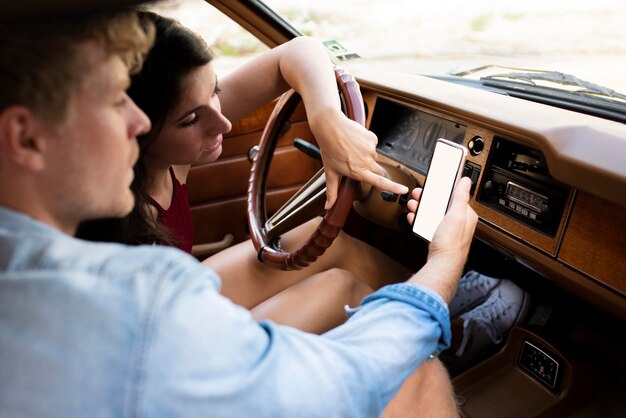 Couple in car looking at smartphone