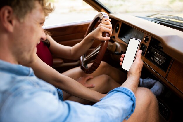 Free photo couple in car with smartphone close up