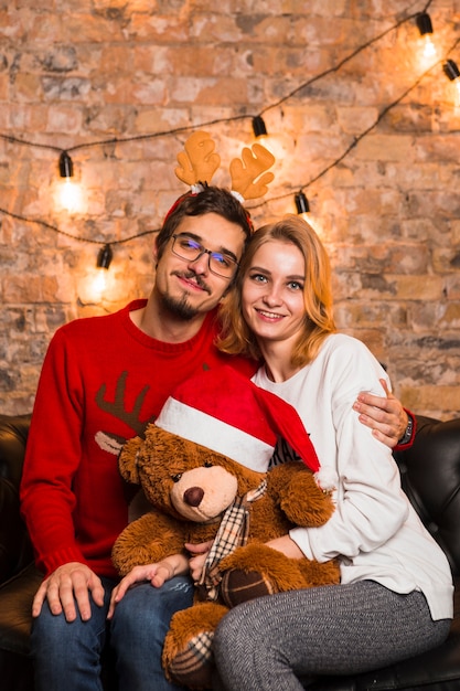 Couple celebrating christmas with teddy bear