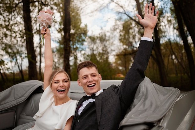 Free photo couple celebrating in their just married car