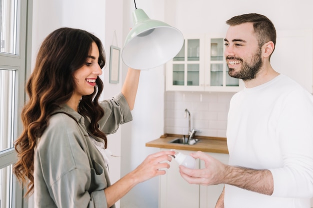 Couple changing bulb at home