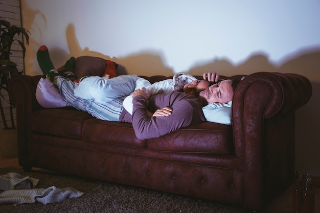 Couple chilling on couch and watching a movie