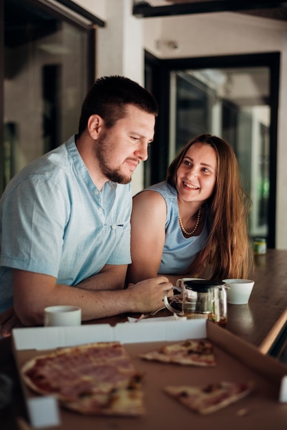 Couple chilling and and having pizza at home