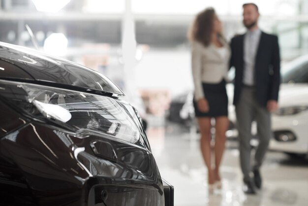 Couple choosing auto in car showroom