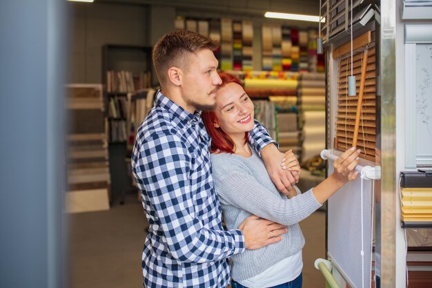 家の装飾店でテキスタイルを選ぶカップル