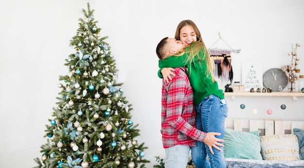Free photo couple next to christmas tree in bedroom