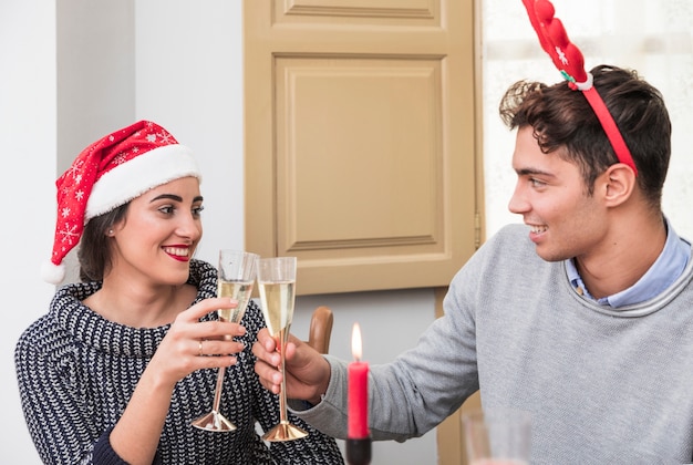 Couple clanging champagne glasses at festive table