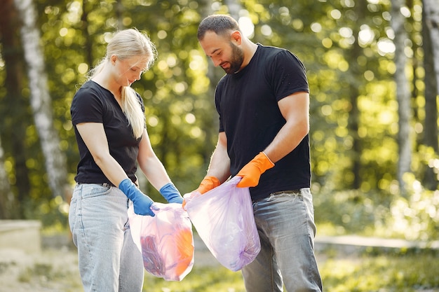 Couple collects garbage in garbage bags in park