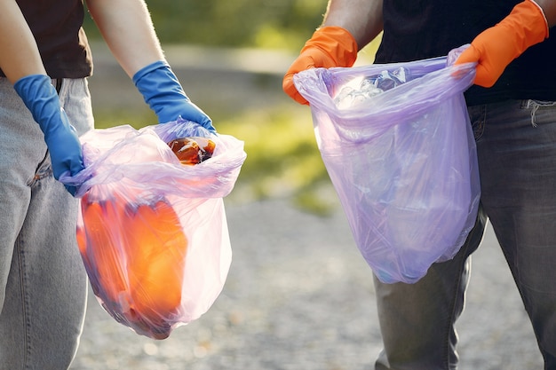 Couple collects garbage in garbage bags in park