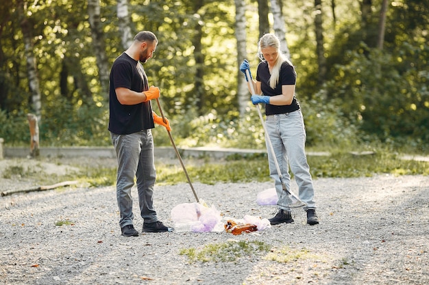 Couple collects garbage in garbage bags in park