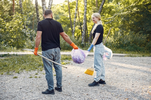 Couple collects garbage in garbage bags in park